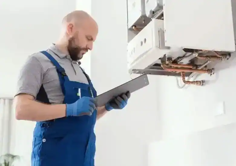 Installateur kontrolliert eine geöffnete Gastherme und notiert Messwerte